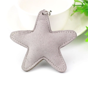 Detailed close-up of a grey star-shaped keychain with silver ring and soft suede texture