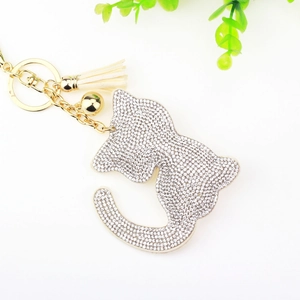 Vue macro d'un porte-clés chat en strass avec pompon blanc et petit grelot doré