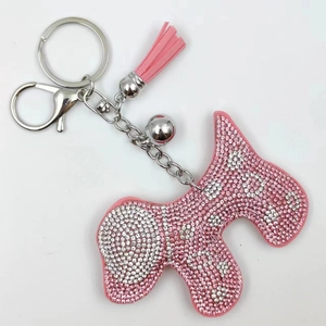 Porte-clés chien en strass rose avec pompon en velours et détail clochette argentée