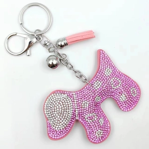Détail d'un porte-clés chien en strass rose avec pompon en cuir et fermoir argenté brillant