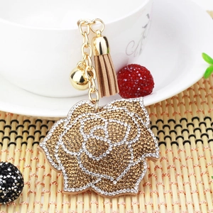 Detail of rose keychain with sparkling gold and silver rhinestones and suede tassel