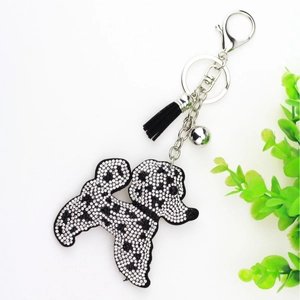 Détail du porte-clés chien en strass avec pompon noir et clochette argentée pour sac