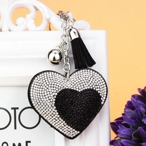 Dettaglio di un portachiavi a cuore scintillante con strass e nappa in pelle nera