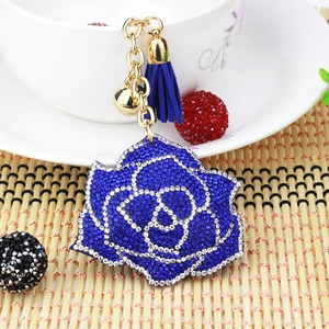 Detailed view of royal blue crystal rose keychain with elegant tassel and gold bell charm