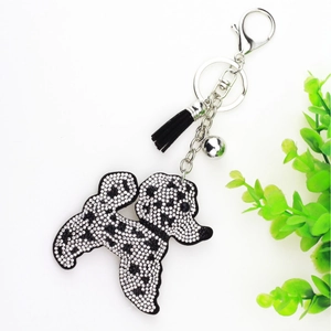 Détail de porte-clés caniche avec strass noirs et blancs, pompon et clochette