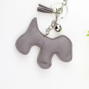 Détail d'un porte-clés chien en velours gris avec pompon et collier en strass brillant