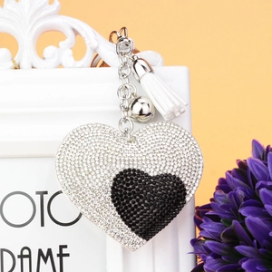 Dettaglio del portachiavi a cuore con cristalli bicolore e nappa bianca decorativa