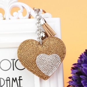 Vista macro del portachiavi a cuore con strass e nappe appeso a una cornice