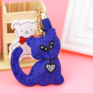 Close-up of dark blue rhinestone cat keychain with golden bell and fringe tassel