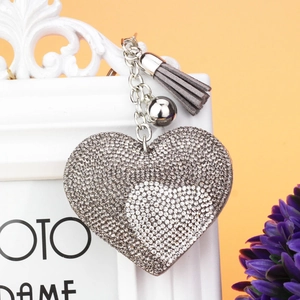 Dettaglio del portachiavi a cuore con strass bianchi e nappa grigia elegante