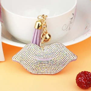 Detail of light purple rhinestone lip keychain with leather tassel and golden bell