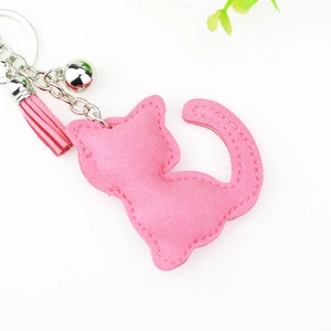Pink velvet cat keychain with decorative tassels and metallic silver bells for bags