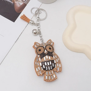 Detailed view of owl keychain with sparkling rhinestones, small bell and suede tassel