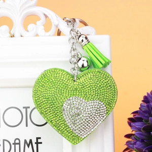 Dettaglio del portachiavi a cuore con strass verdi e argento con nappa e clip in metallo