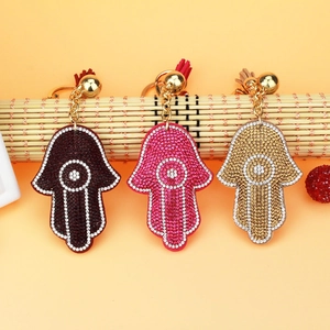 Detailed view of Hamsa Hand keychains with rhinestones and matching tassels in various colors
