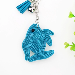 Macro detail of sparkling blue rhinestone dolphin keychain with a stylish leather tassel