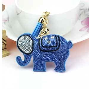 Detail of royal blue rhinestone elephant keychain with faux leather tassel and gold bell