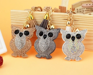 Detailed close-up of three owl keychains with rhinestones and matching leather tassels