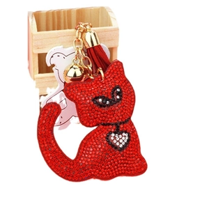 Sparkling red rhinestone cat keychain with golden bell and leather tassel on white