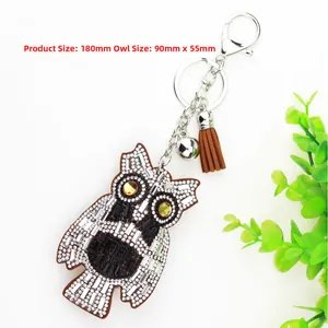 Detailed view of rhinestone owl keychain with brown leather tassel and silver metal ring