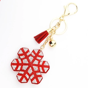 Detail of red snowflake keychain with crystal rhinestones, gold clasp, and velvet tassel