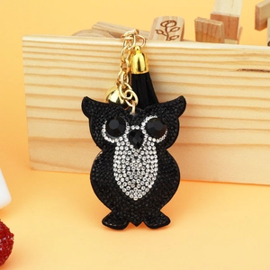 Detail of owl keychain with sparkling rhinestones, black tassel, and gold-tone bell accents