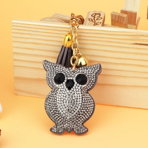 Macro detail of diamond owl keychain with silver rhinestones and a grey tassel charm