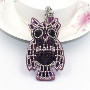 Close-up of purple owl keychain with shimmering rhinestones and soft tassel detail