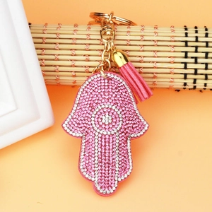 Detailed view of pink Hamsa hand keychain with rhinestones and matching tassel pendant
