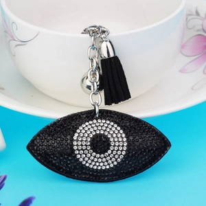 Macro view of black Evil Eye keychain with sparkling rhinestones and a soft fabric tassel