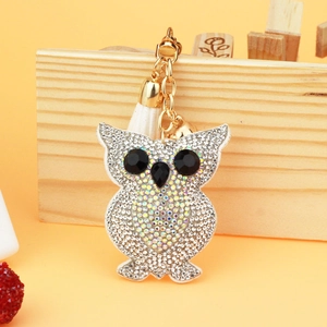 Macro shot of sparkling crystal owl keychain with white tassel and golden link