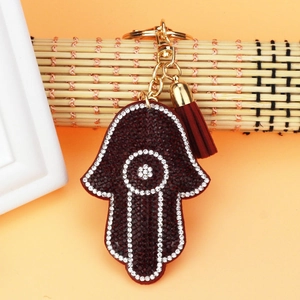 Detailed view of Hamsa Hand keychain with red rhinestones and golden silk tassel detail