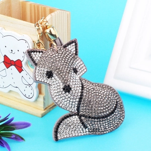 Detailed view of fox keychain with sparkling silver and black rhinestones on blue background