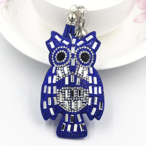 Detailed view of a dark blue rhinestone owl keychain with decorative silk tassel