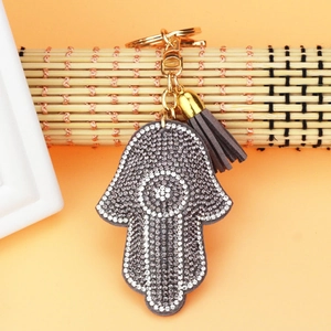 Detail of Hamsa Hand keychain with silver rhinestones and brown suede tassel charm