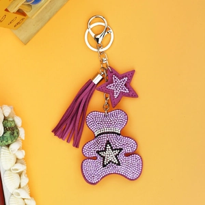 Detailed view of a purple bear keychain with sparkling rhinestones and a long soft tassel