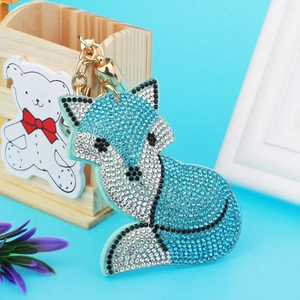 Close-up of sparkling blue and white rhinestone fox keychain with gold metal chain
