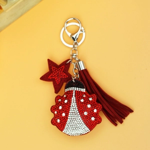 Sparkling rhinestone ladybug keychain with red tassel and star charm on yellow backdrop