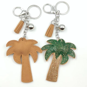Sparkling palm tree keychain with green rhinestones and leather tassel on white background