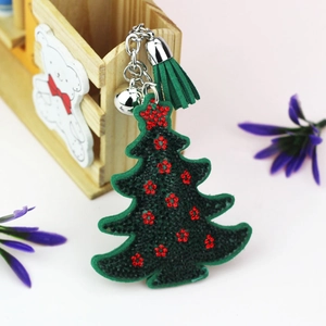 Détails d'un porte-clés sapin de Noël en velours vert avec strass rouges et un pompon