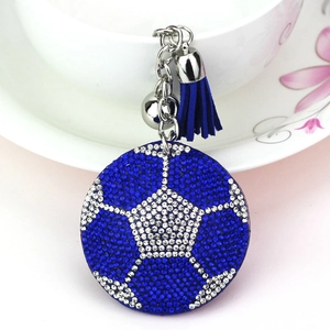Gros plan sur un porte-clés de football en strass bleu et argent avec gland en daim