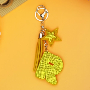 Detail of yellow letter R keychain with sparkling rhinestones and suede tassel charm