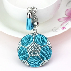 Détail d'un porte-clés de football avec strass bleus et blancs et pompon en velours