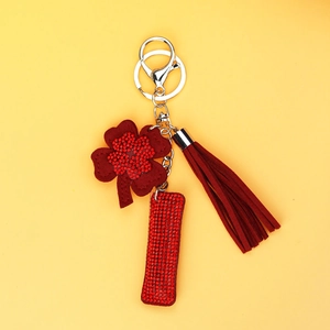 Close-up of red four-leaf clover keychain with sparkling rhinestones and suede tassel