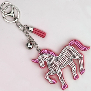 Nahaufnahme von rosa Einhorn-Schlüsselanhänger mit Strass, Silberglocke und Wildlederquaste