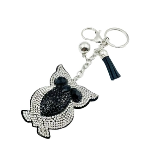 Creative owl keychain with rhinestones, silver bell and black tassel on white background