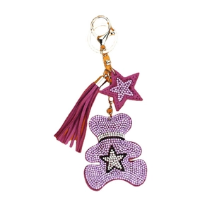 Sparkly purple rhinestone bear keychain with tassel and star charms on white background