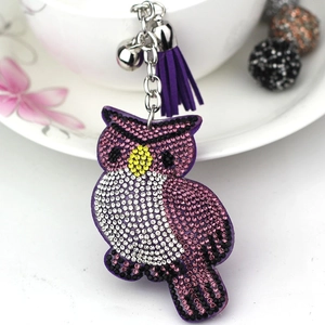 Vue détaillée du porte-clés hibou avec franges violettes, strass et clochette argentée