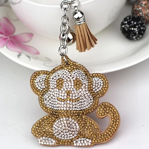 Cute monkey keychain with champagne rhinestones, brown tassel and silver bell detail