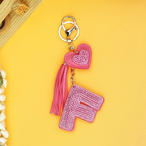 Detailed view of pink rhinestone letter F keychain with a tassel and heart charm
